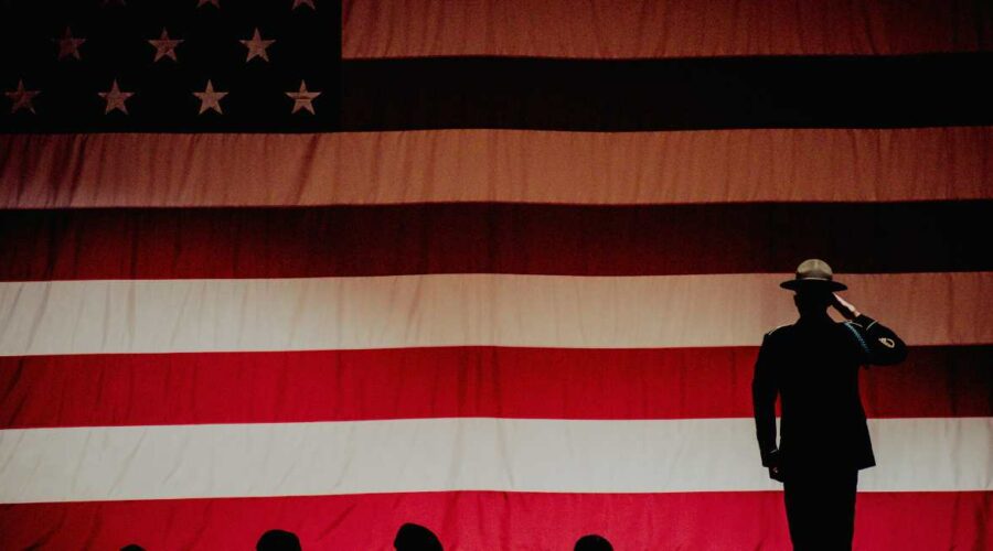 Veteran on stage saluting flag.