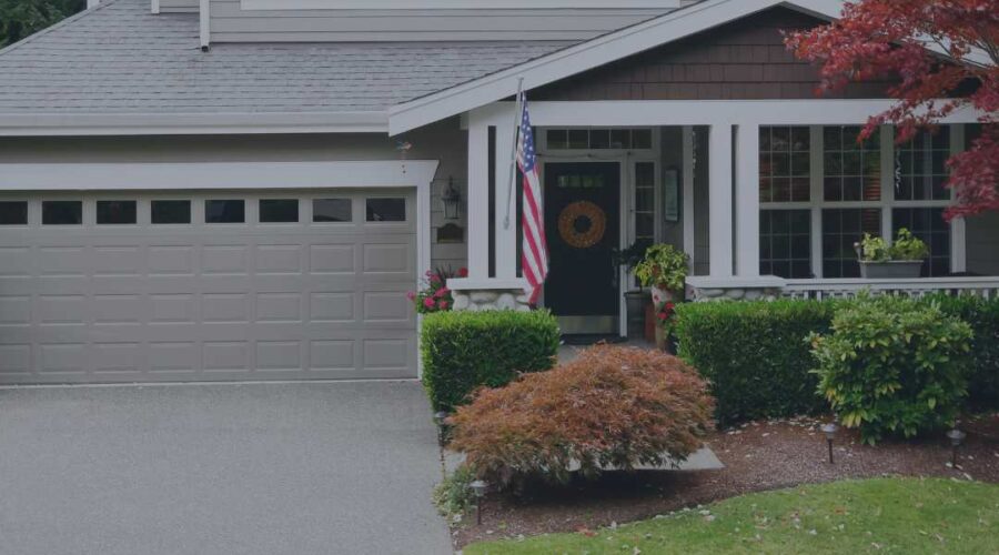 Photo of beautiful home with clean front yard, flowers, and a front porch.