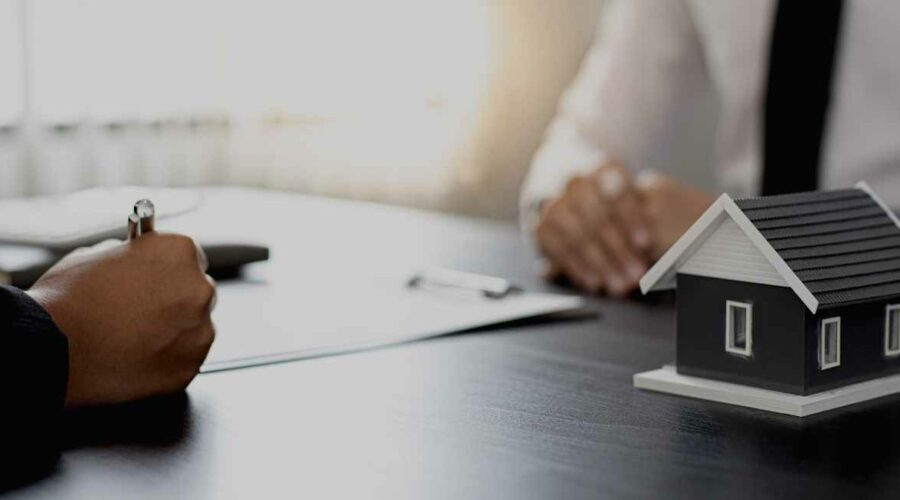 Image shows people sitting at a table filling out paperwork, as one would do when listing their home with an Asheville Realty Group Realtor.