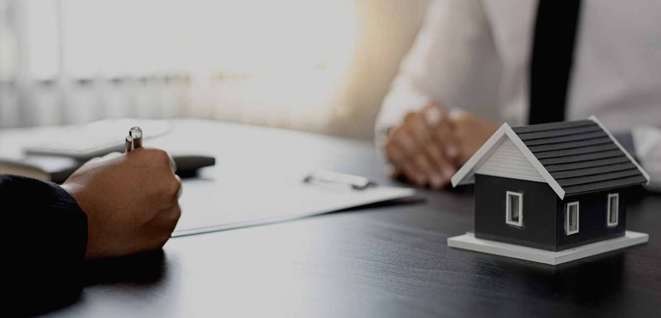 Image shows people sitting at a table filling out paperwork, as one would do when listing their home with an Asheville Realty Group Realtor.