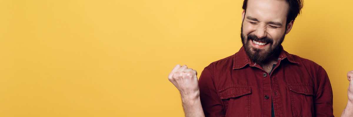 Picture of happy guy doing a fist pump after buying a house with the best realtor.